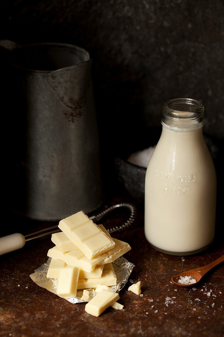 weiße Schokoladenstücke und Milchflasche