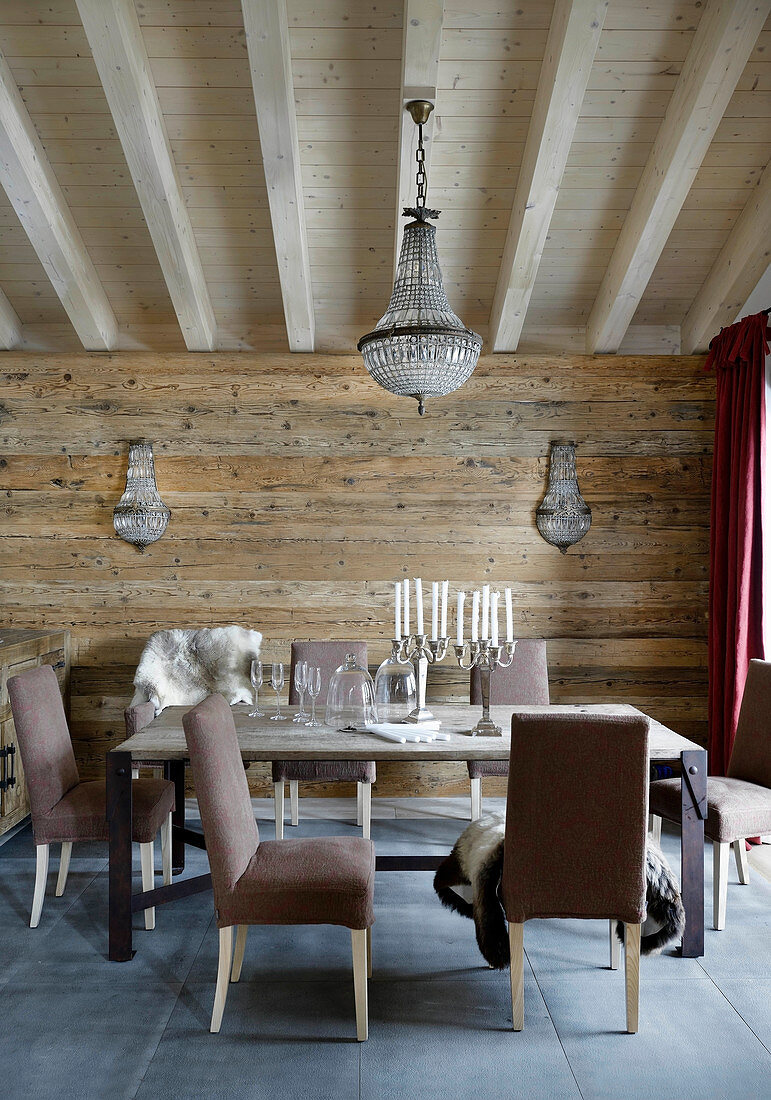 Braune Polsterstühle um den Tisch im Esszimmer eines Chalets