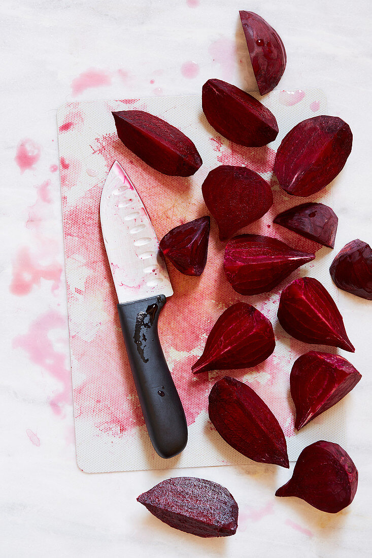 In Spalten geschnittene Rote-Bete mit Messer auf Schneidebrett