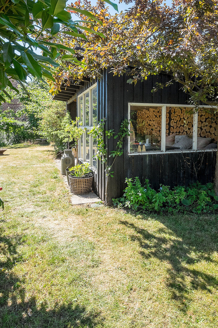 Summerhouse with large windows in summery garden