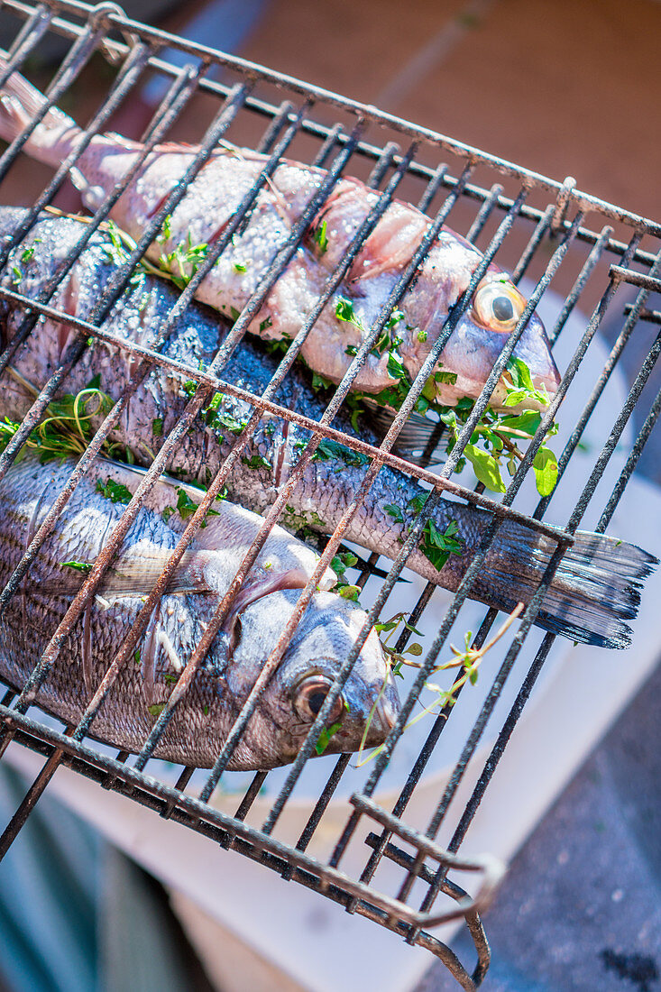 Fish stuffed with herbs in grilling baskets