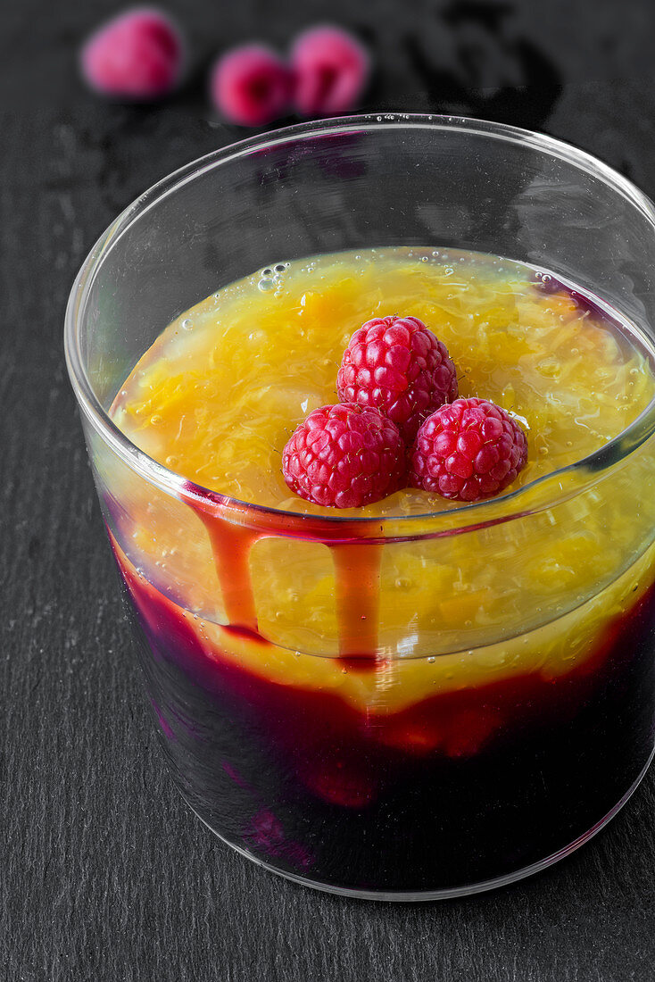 Cherry compote with mango, peach, and pomegranate in a glass (close up)