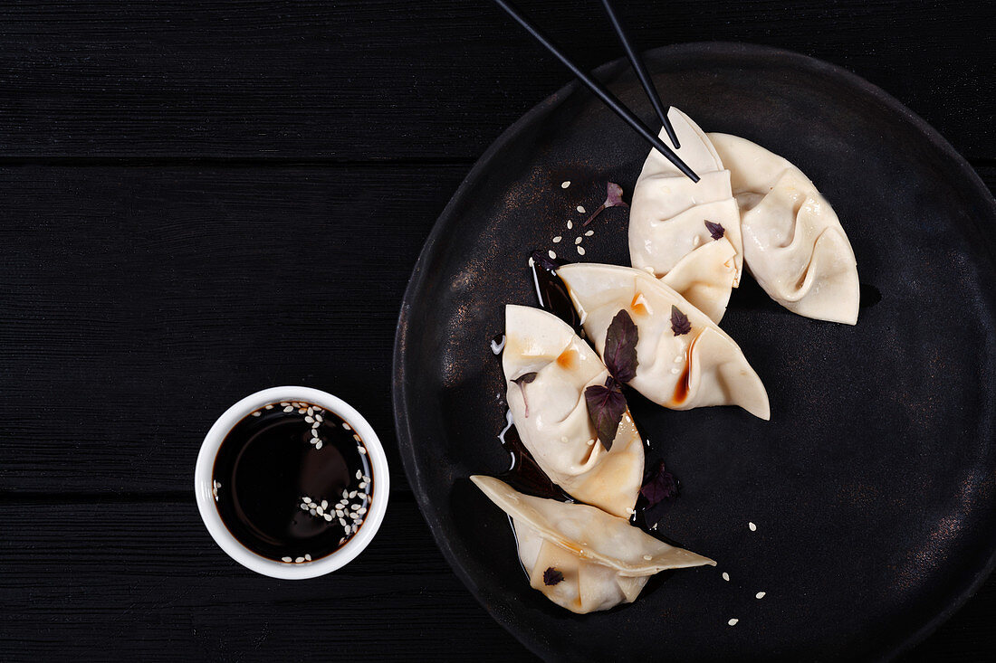 Gyoza (Japanese dumplings) with soy sauce and sesame seeds