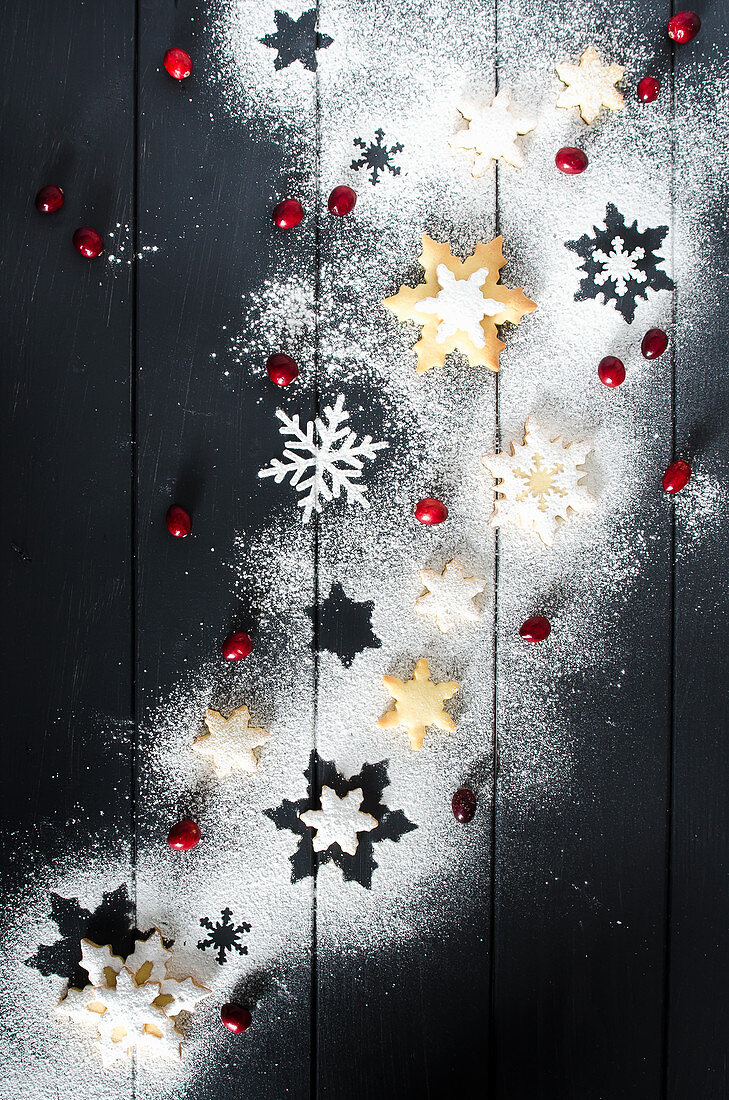 Schneeflocken-Plätzchen mit Zuckerglasur auf blauem Holzuntergrund