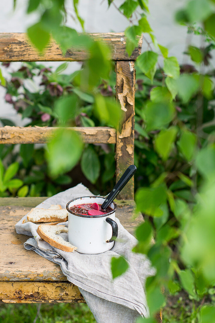 Rote Bete Suppe in Emaillebecher mit Weißbrot