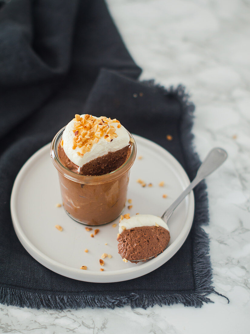 Schokoladenmousse mit Sahnehäubchen und gehackten Haselnüssen