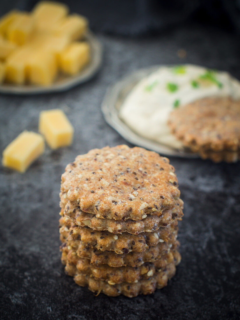 A stack of homemade crackers with seeds, almonds and Parmesan