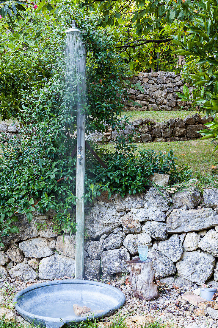 Außendusche mit Natursteineinfassung im Garten