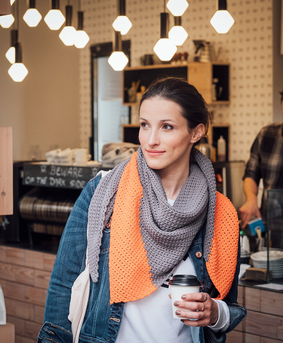 A woman wearing a bi-coloured, crocheted scarf