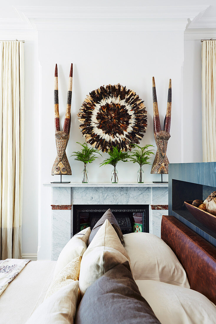 View of mantelpiece over bed with tribal pillows