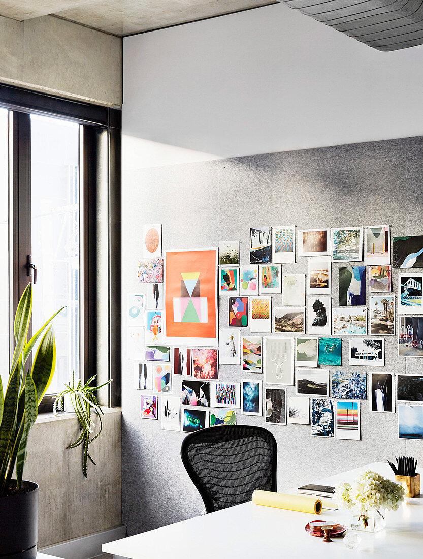 Postcard collection on pin board, white desk with black chair in study