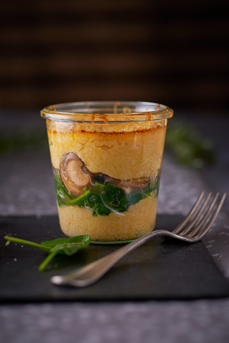 Polenta gratin with spinach and mushrooms in a jar