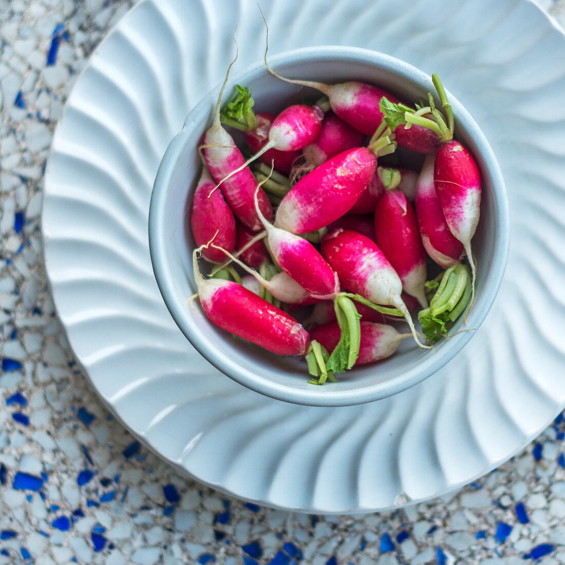 Fresh radishes in a porcelain bowl (seen from above)