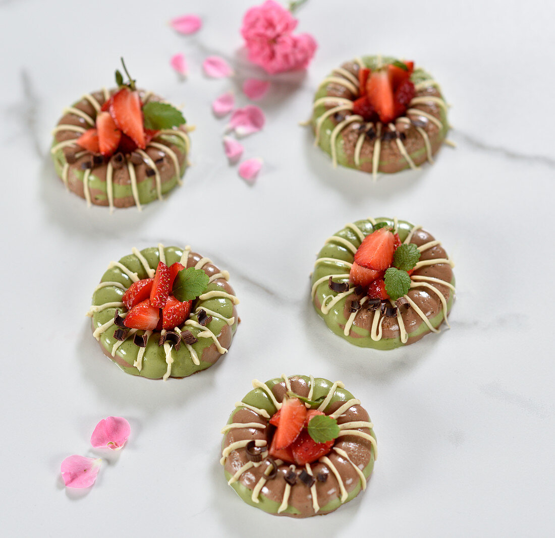 Vegane Matcha-Schoko-Törtchen mit weißer Schokoladenglasur und frischen Erdbeeren