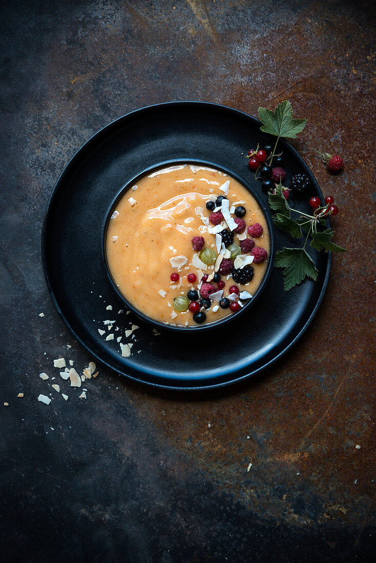 Aprikosen-Bananen-Nicecream Bowl mit frischen Beeren, Mandeln und Kokosraspeln