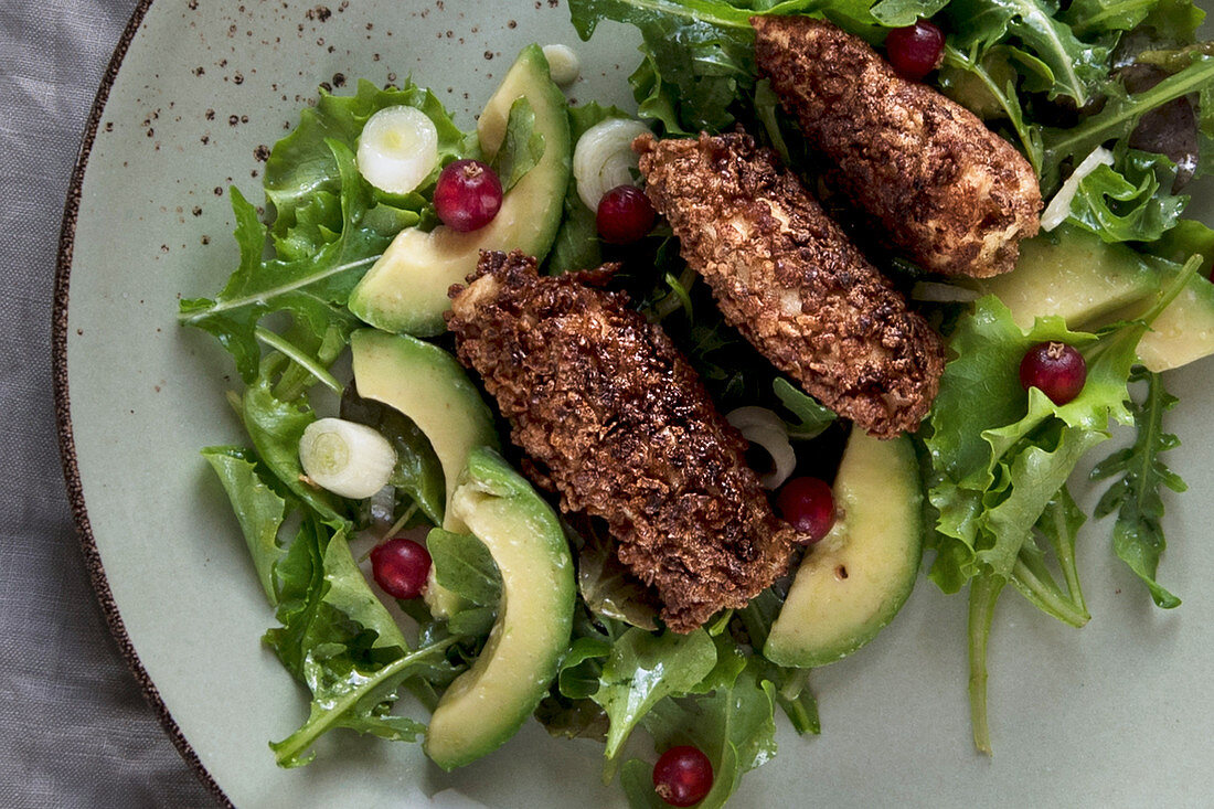 Crispy chicken on a mixed leaf salad with avocado