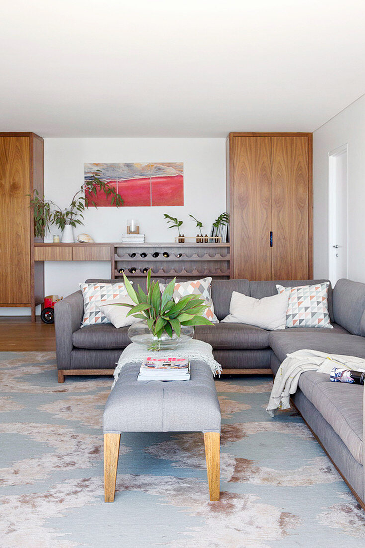 Gray upholstered bench as a coffee table in front of the gray sofa