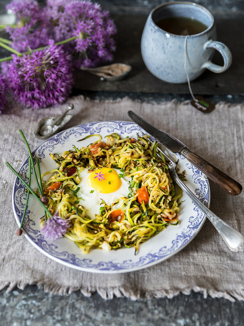 Zucchinispaghetti mit Knoblauch, Ingwer, Chili, pochiertem Ei und Tomaten