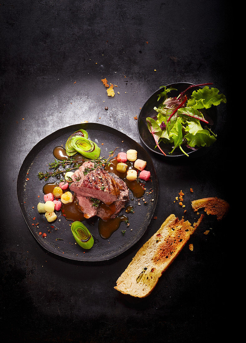 A steak dish with a garlic baguette