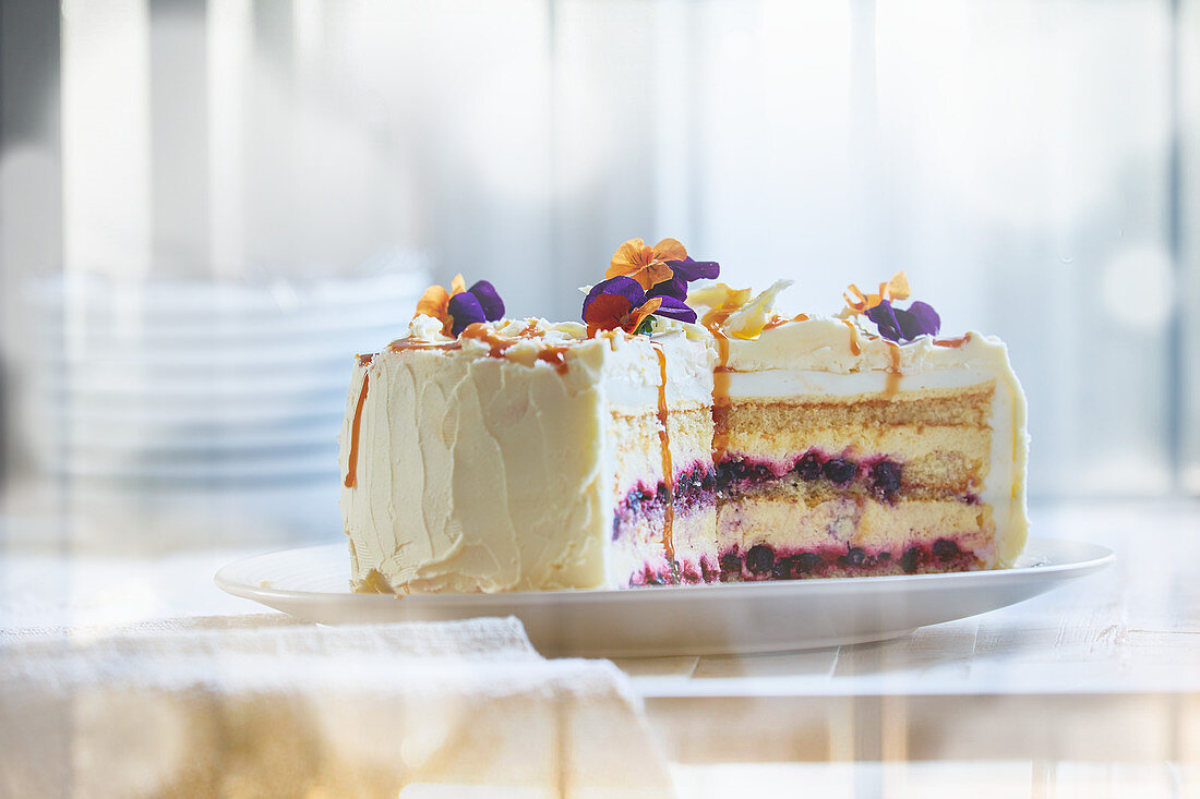 Cream cheese cake with berries and edible flowers