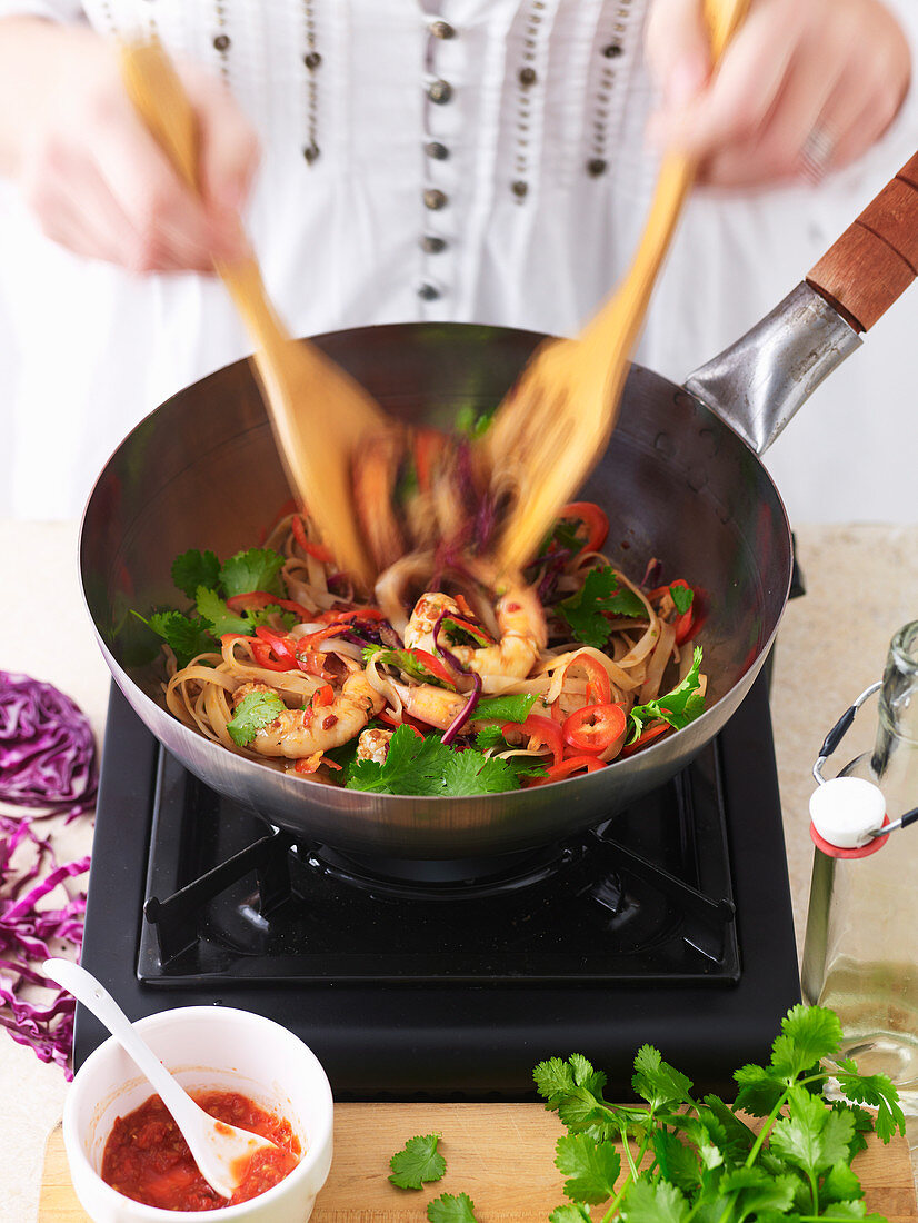 Woman Stir-Frying Chilli Prawns with Noodles