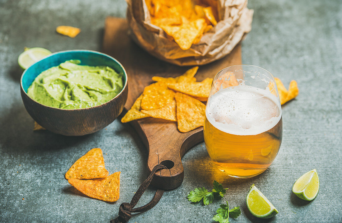 Mexican corn chips, guacamole sauce and glass of wheat beer