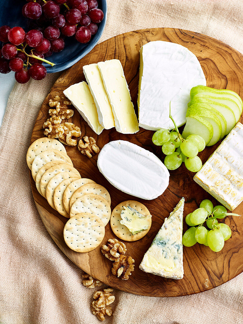 Käseplatte mit Trauben, Birne, Walnüssen und Crackern