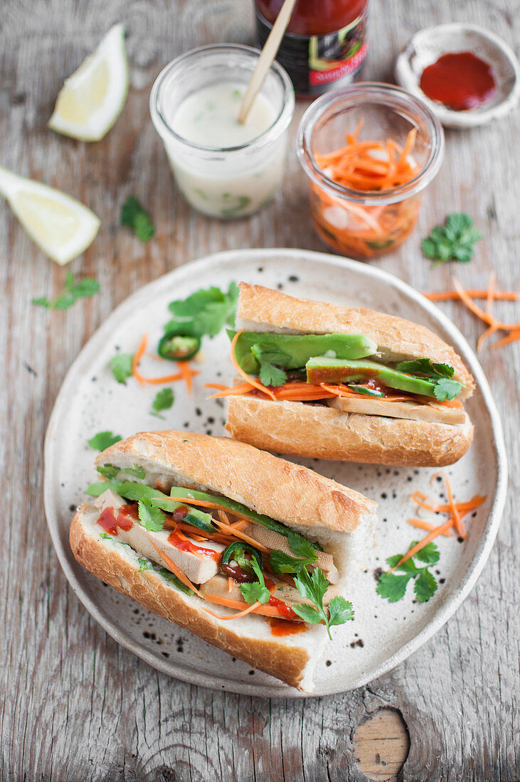 Veganes Banh-Mi-Sandwich mit Tofu, Avocado, eingelegten Möhren, veganer Mayo und Sriracha