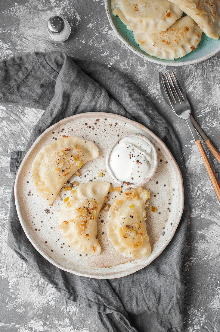 Dumplings with potatoes, cottage cheese and fried onion (pierogi ruskie), served with sour cream