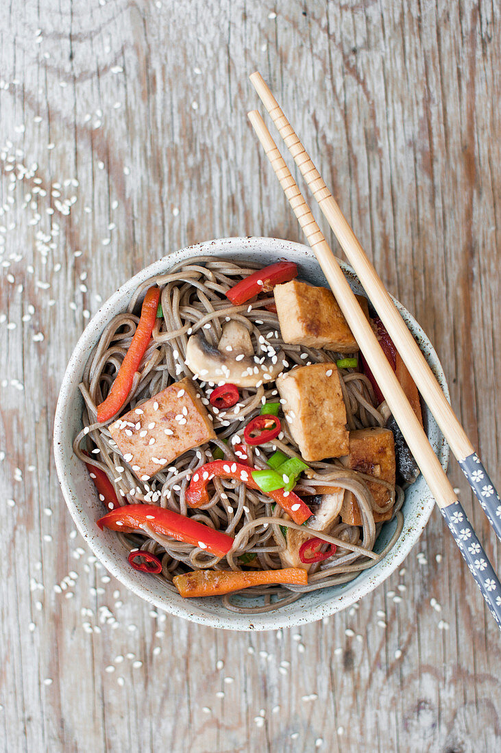 Yaki soba with tofu, bell pepper and mushrooms, sprinkled with green onion, sesame and fresh chili (glutenfree)