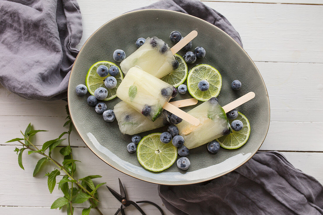 Blueberry mojito cocktail ice lollies in a dish