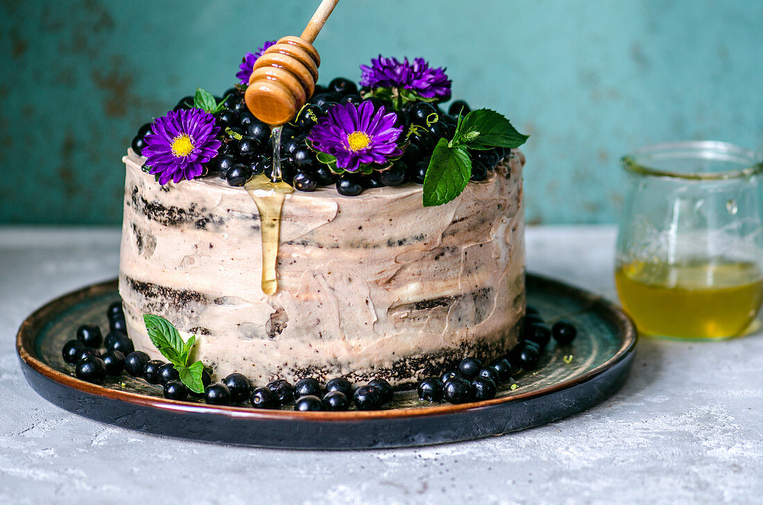 Naked Cake mit Traubenkirschen, Blumen und Honig
