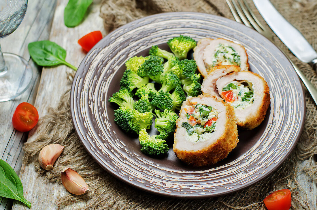 Turkey rolls filled with ricotta, spinach and tomato served with blanched broccoli florets