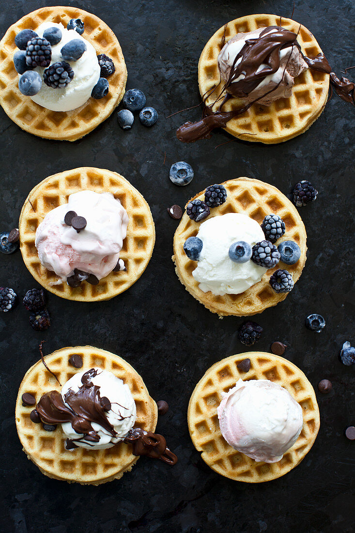 Waffles topped with vanilla, strawberry and chocolate ice cream, melted chocolate, frozen berries and chocolate chips