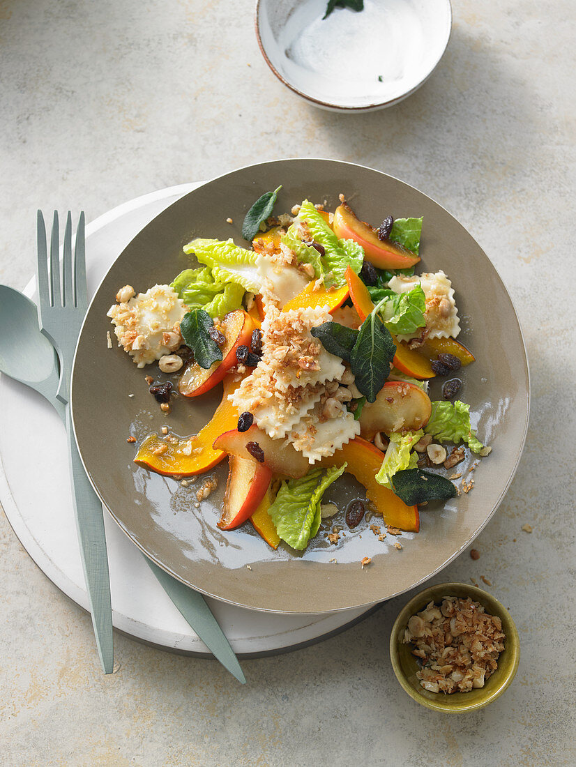 Sweet-and-sour pumpkin and apple salad with sage and raisins on fried ravioli on crispy breadcrumbs