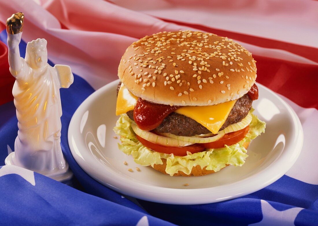Ein Cheeseburger auf Teller, Deko: kleine Freiheitstatue