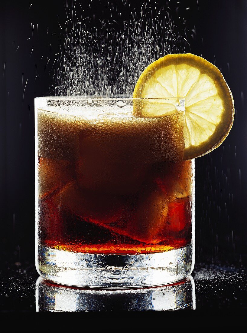 Sparkling cola with ice and lemon