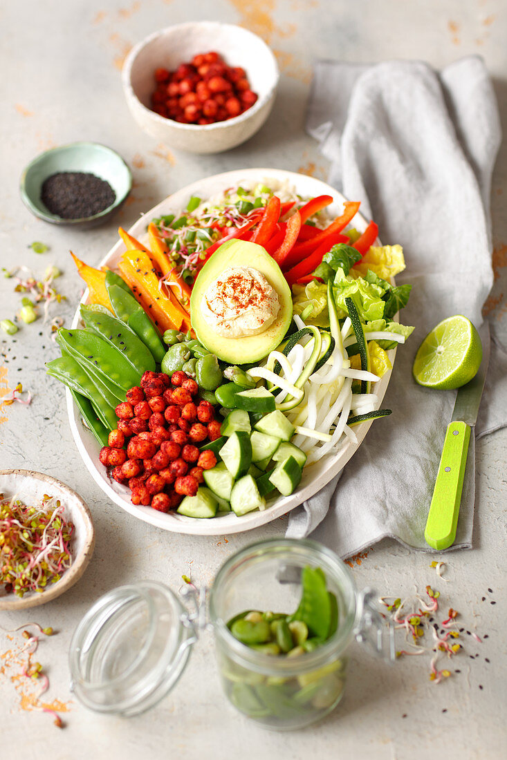 Vegane Buddha Bowl mit Hummus, Avocado, Süsskartoffeln, gebackenen Kichererbsen und Gemüse