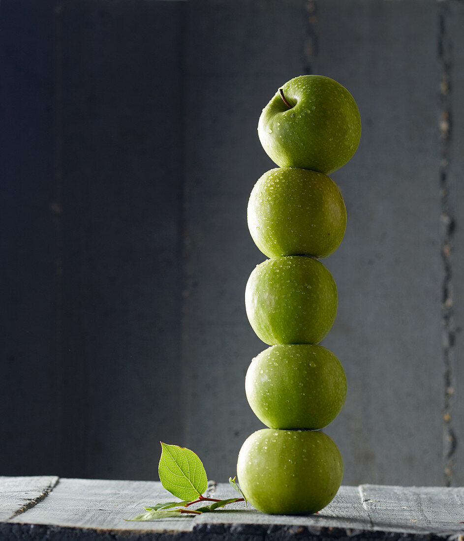 Green apples stacked in a tower