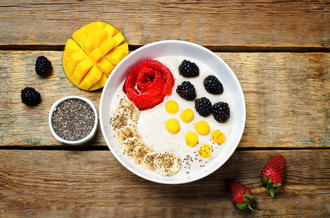 Frühstücks-Porridge mit Erdbeeren, Mango, Brombeeren, Bananen und Chiasamen