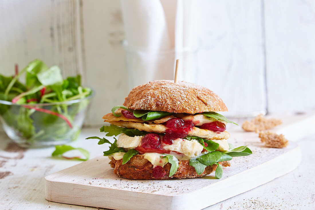 A chicken burger with camembert and cranberry sauce