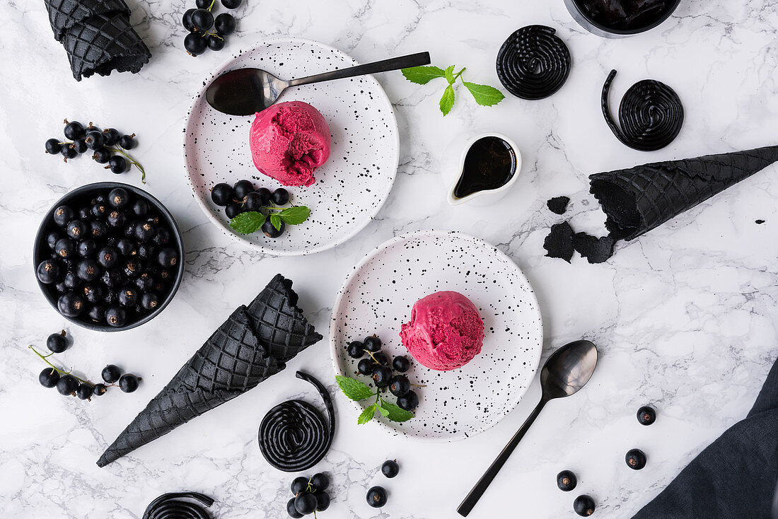 Lakritzeis mit schwarzer Johannisbeere auf weissen Desserttellern
