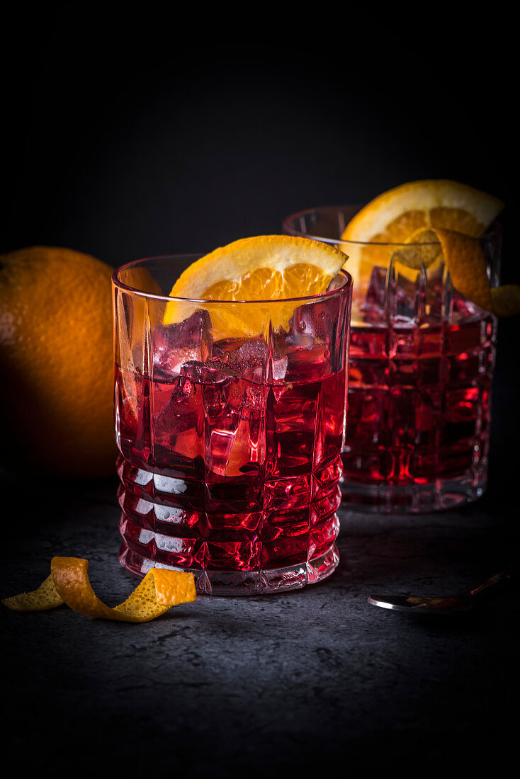 Classic Italian cocktail: Negroni on ice with oranges in glasses