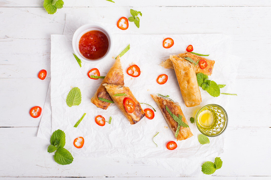 Spicy spring rolls served with fresh chili peppers, fresh mint and spicy sauce