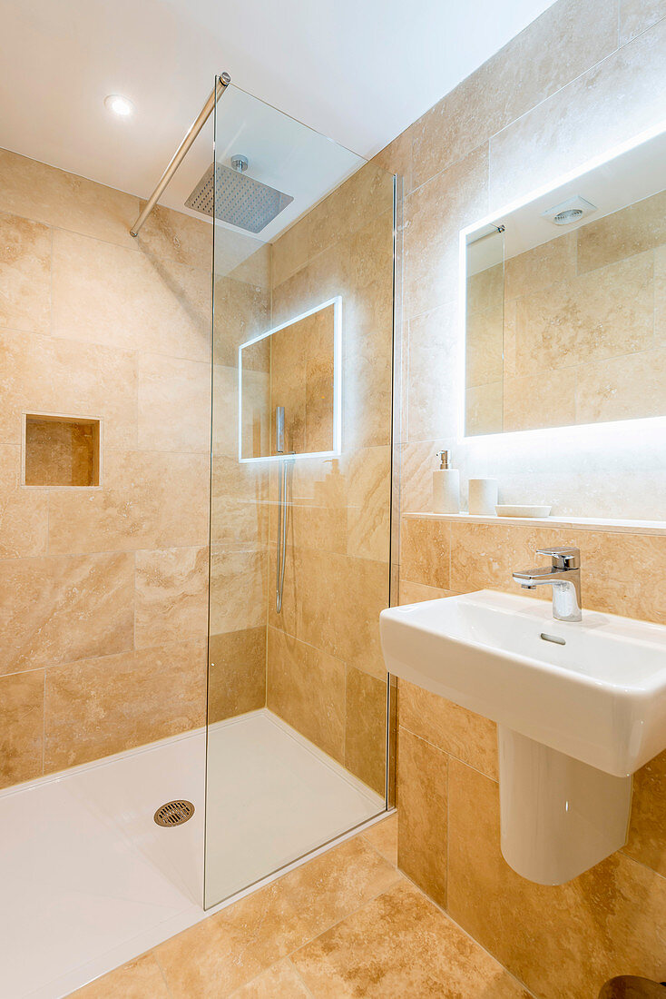 Mirror with indirect lighting in bathroom in sandy shades