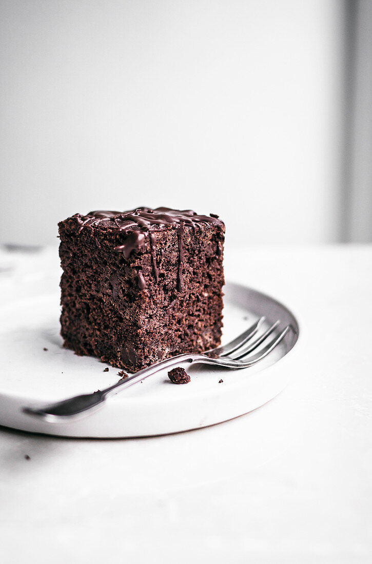 Ein Stück Schokoladenkuchen mit dunkler Schokoladenglasur