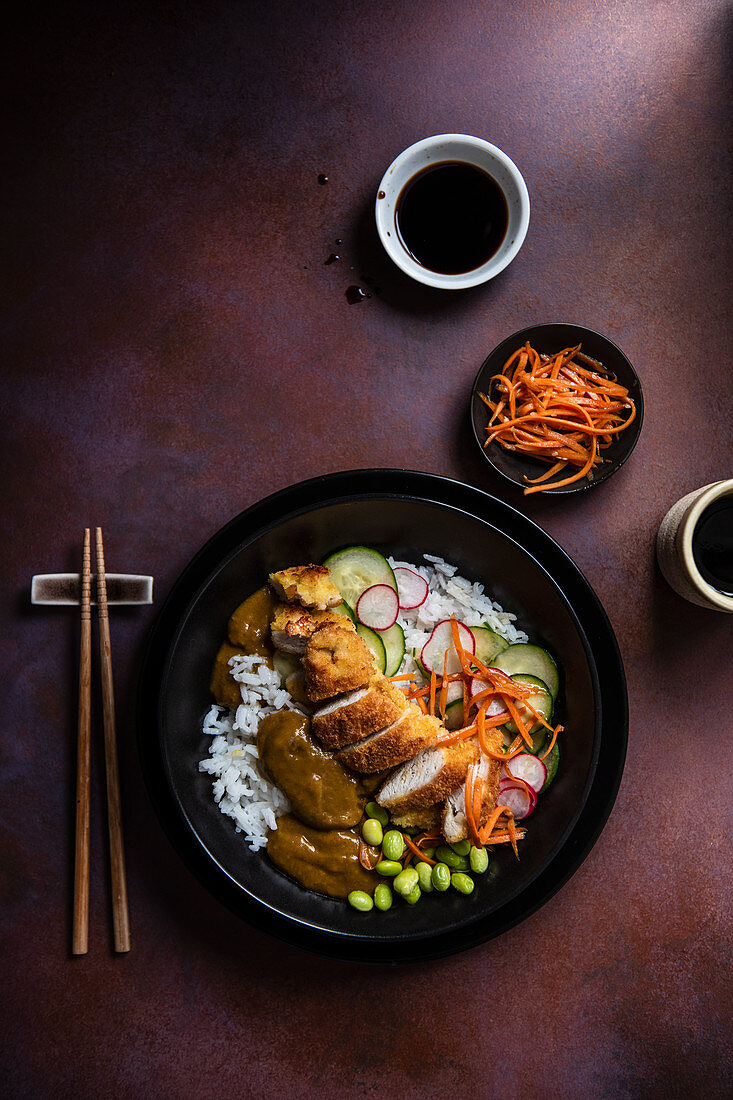 Japanese katsu chicken with pickled cucumber, carrots in seasame oil and edame beans