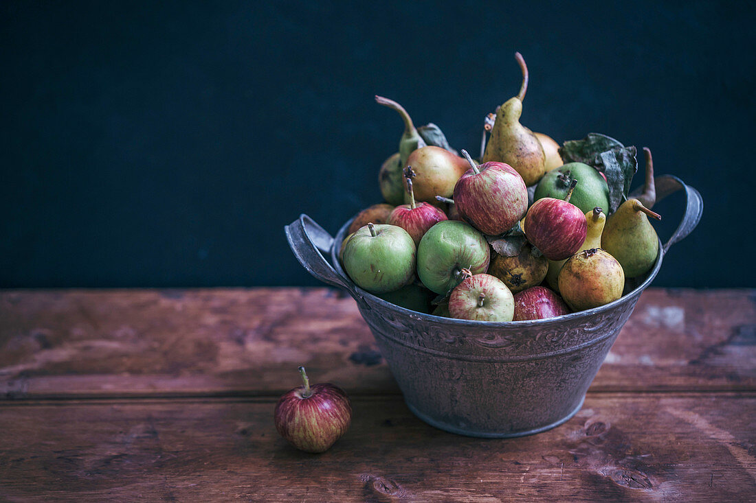 Organic apples and pears in a rustic bucket