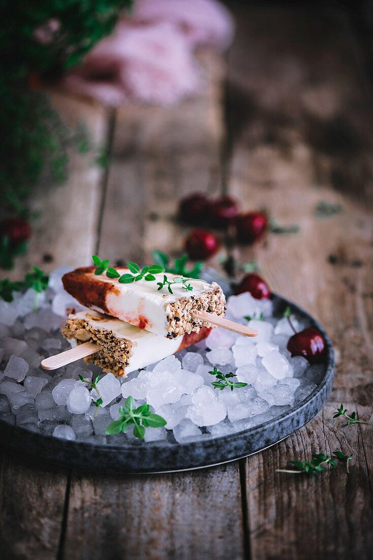 Zwei Joghurteis am Stiel aus griechischem Joghurt und Kirschen