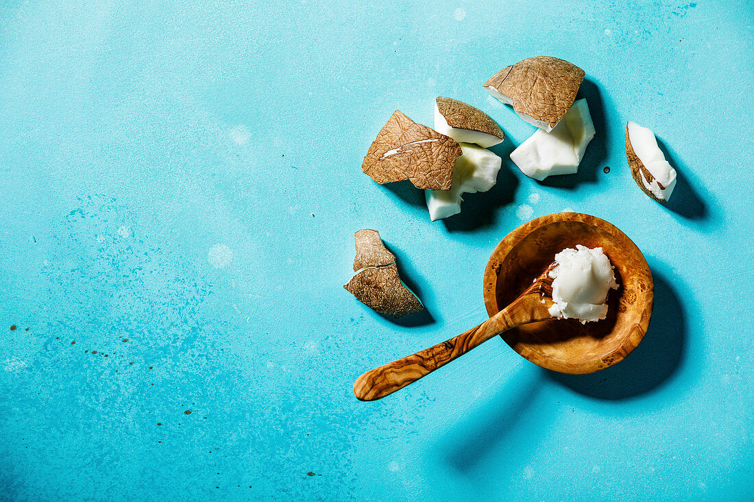 Organic healthy Coconut butter and fresh coconut pieces on bue background copy space